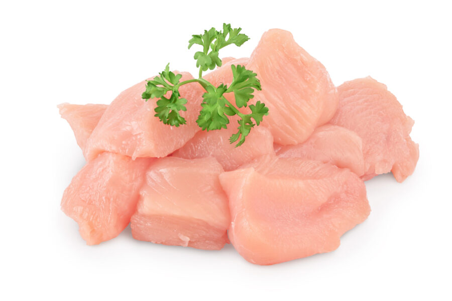 Fresh diced chicken fillet with parsley isolated on white background with clipping path and full depth of field. Meat