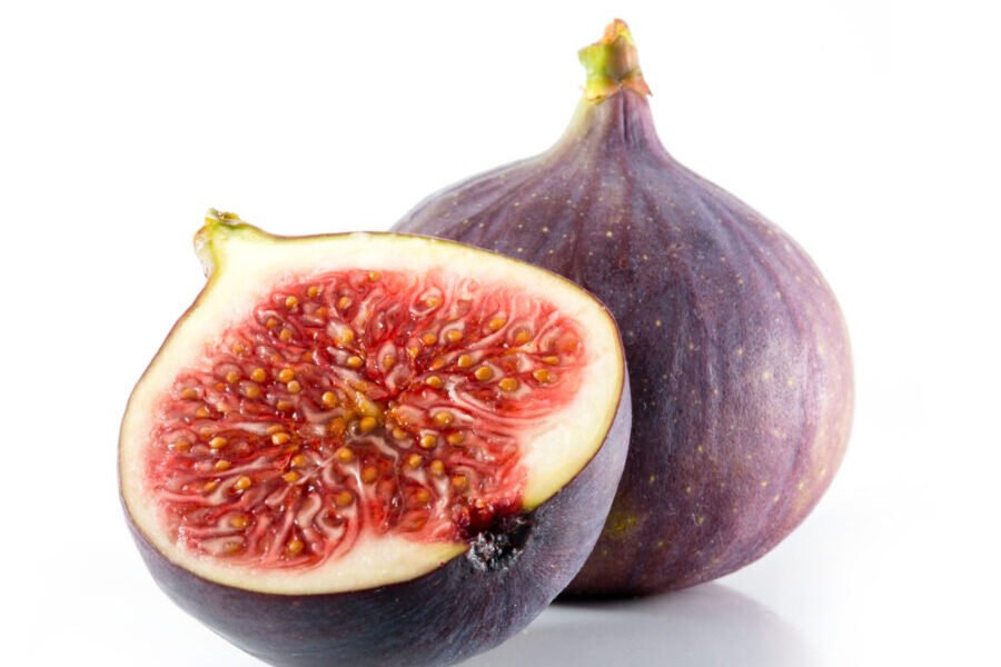 A halved and whole fig isolated on a white background Produce